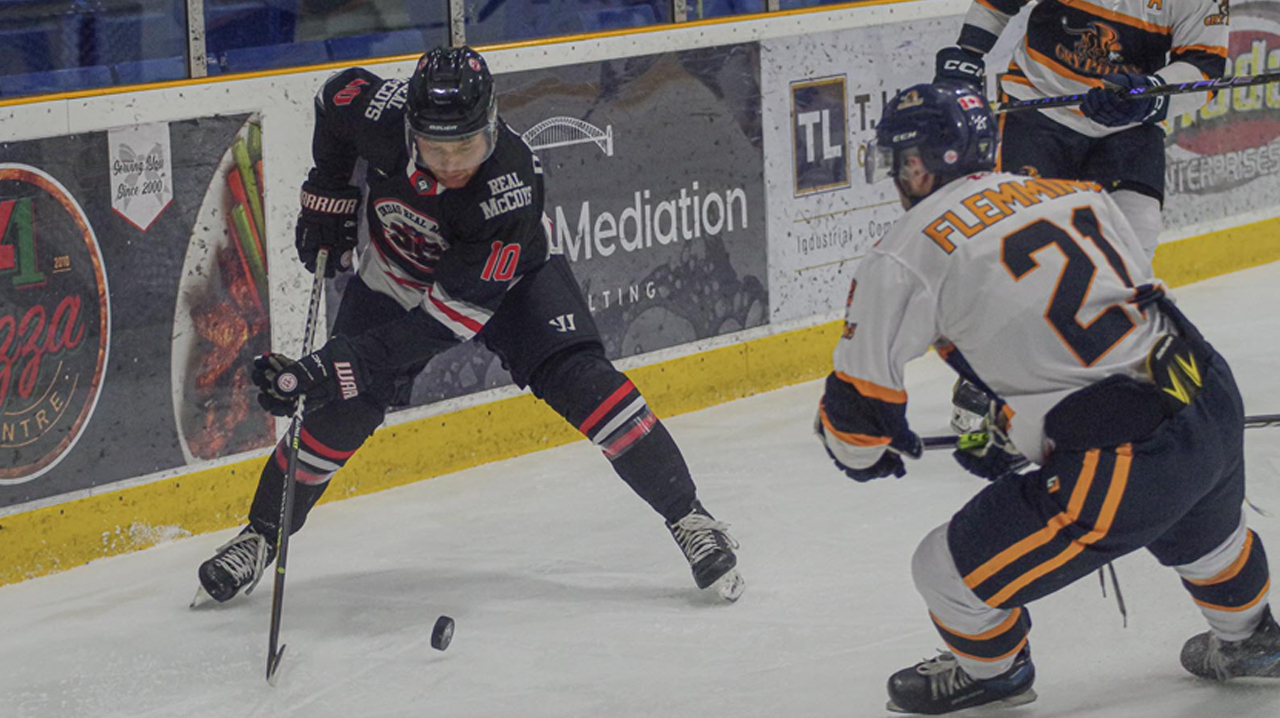 Doggett collects a bouncing puck as Wentworth's Flemming comes to him