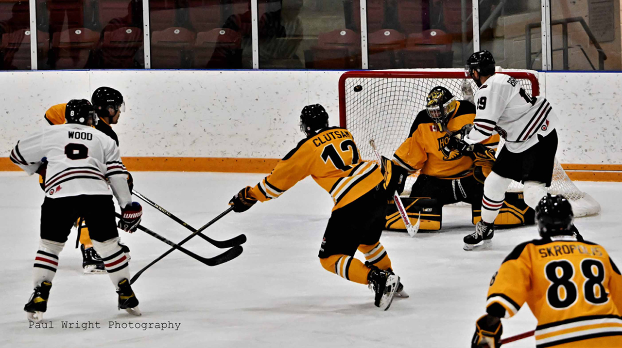 Hornets swarm Mackenzie Wood while Simon Magos tries to tip the puck in