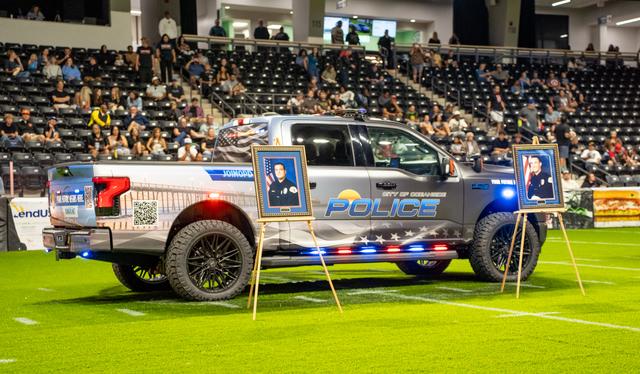Police truck in the arena displaying two fallen officers photos.
