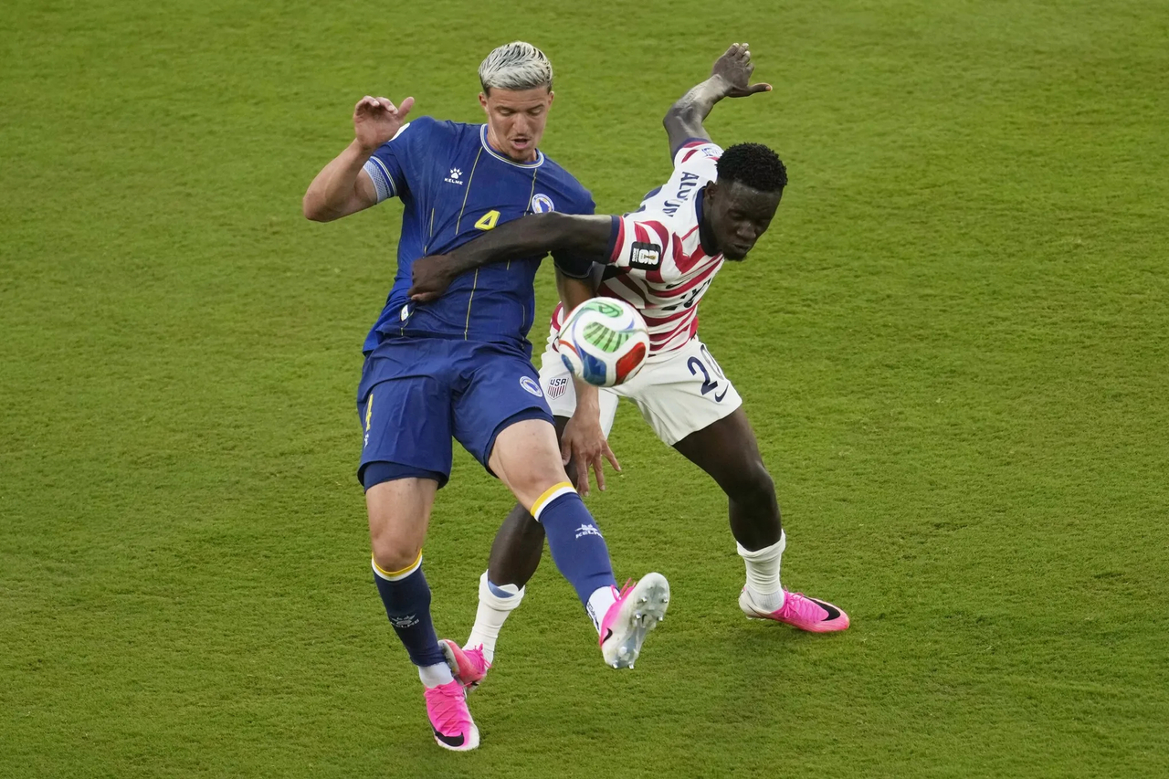 USA and Bosnian players collide towards ball.