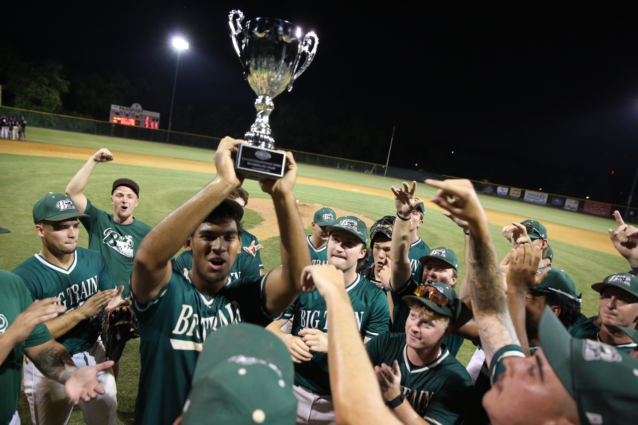 Emilio Gonzalez hoisting trophy by Mark Thalman